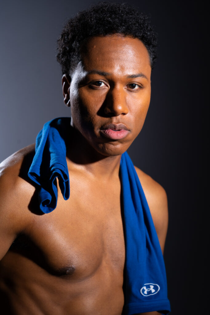 Shirtless man looking into camera with tank top around his neck