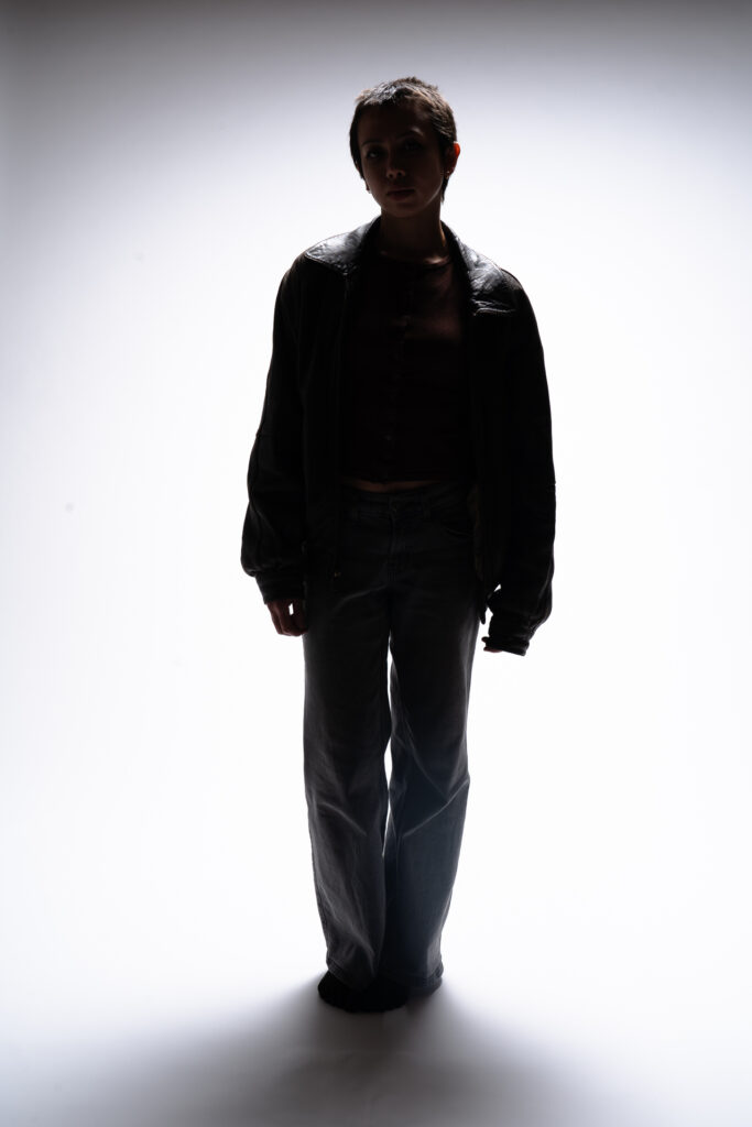 Woman with bright light behind her, shadows across her figure