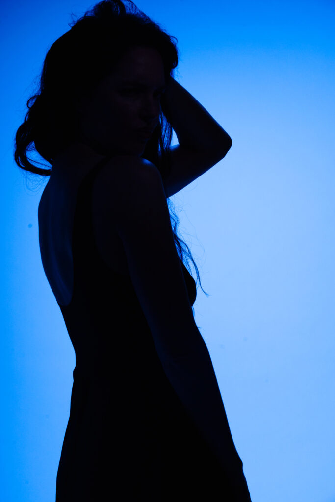 Silhouette of woman against blue background